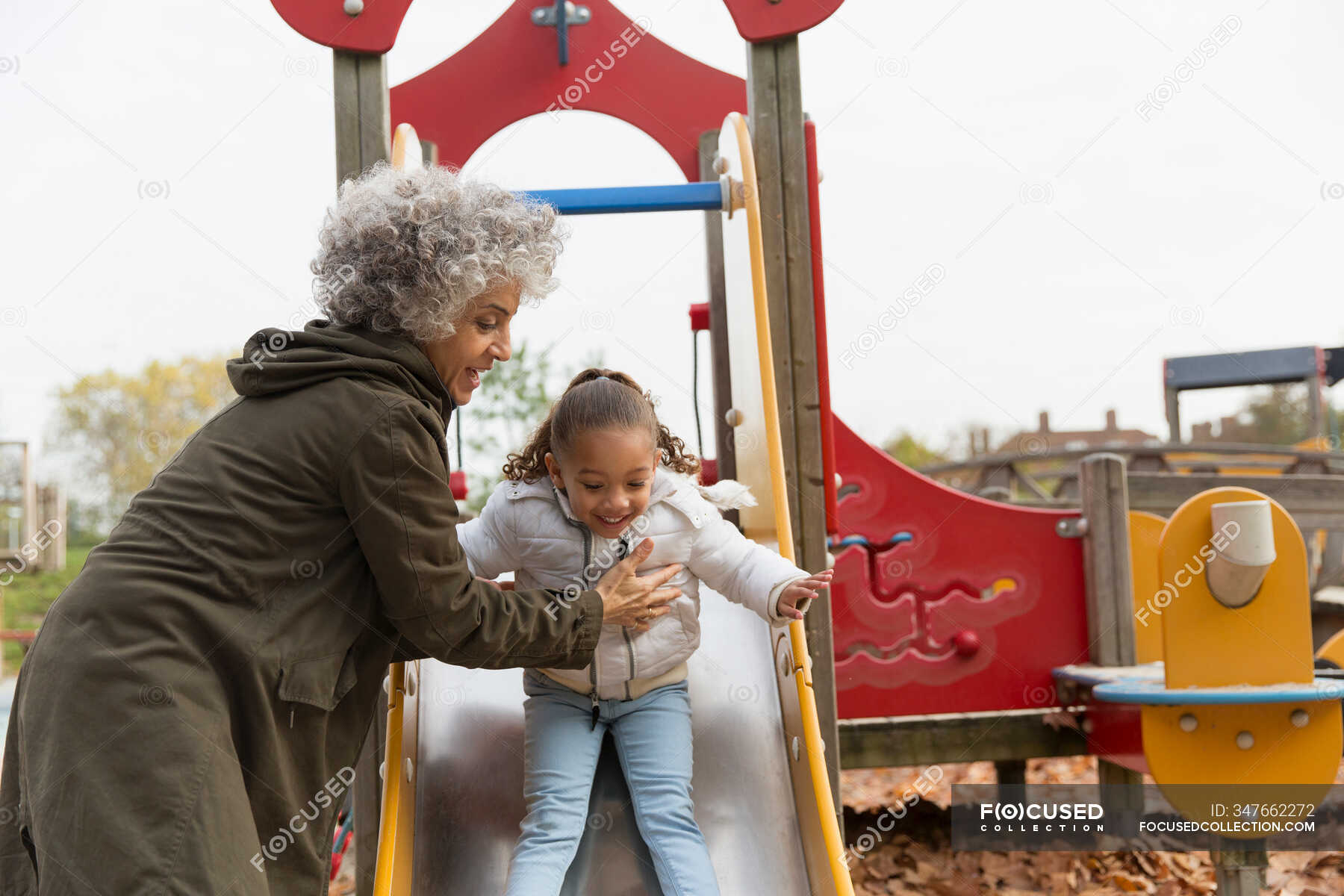 Бабушка играет с внучкой на горке — Няня, защита - Stock Photo | #347662272