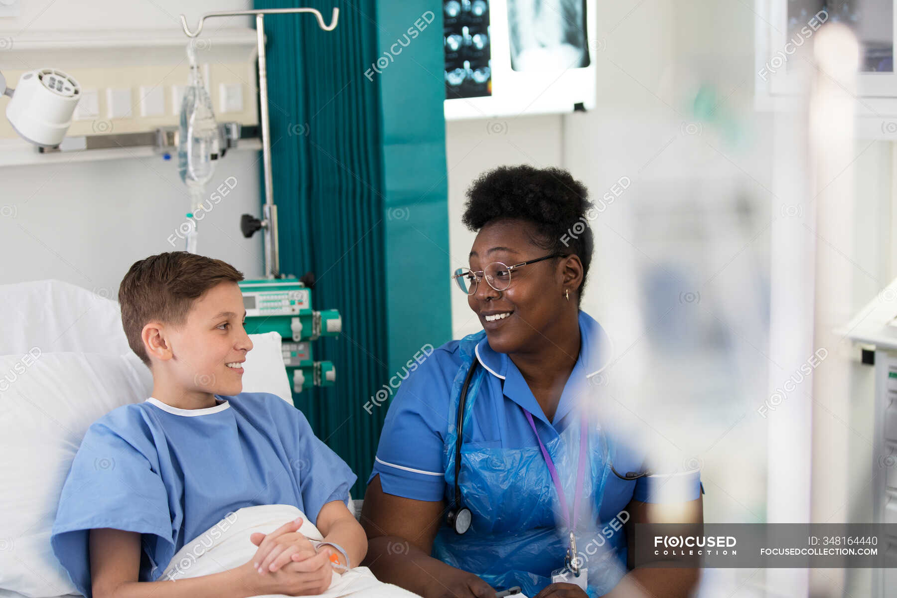 Female nurse talking with boy patient in hospital room — recovery ...