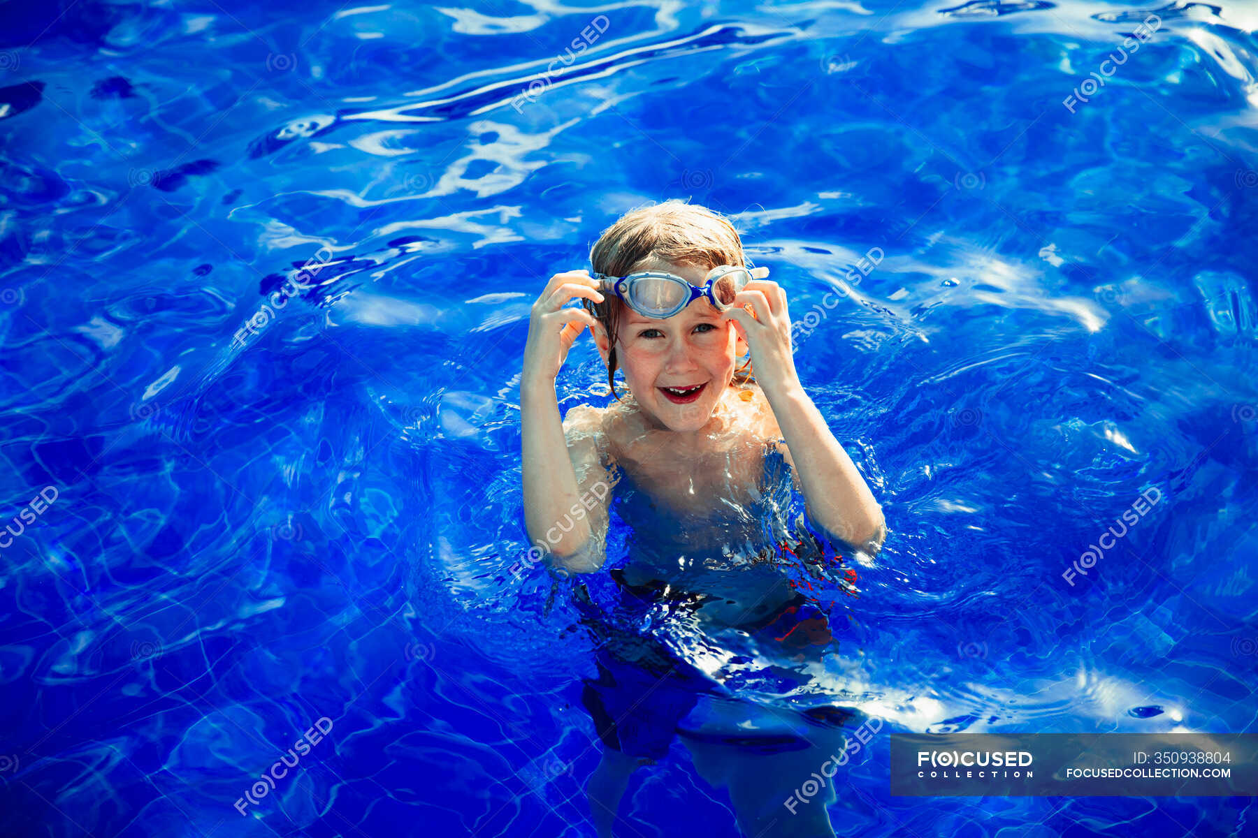 Portrait happy boy swimming in sunny blue swimming book — enthusiasm ...