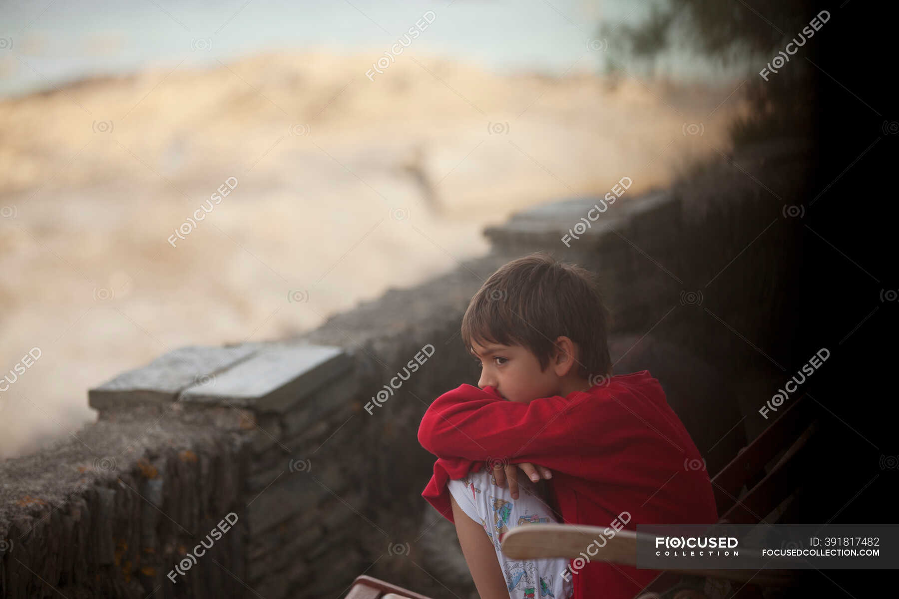 Pensive boy sitting along rock wall — hope, side view - Stock Photo ...