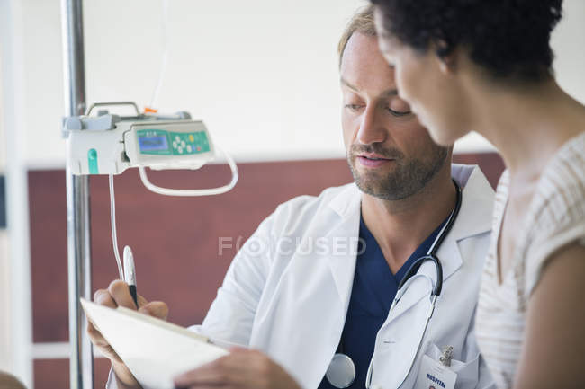 Médico e paciente conversando no hospital um com o outro — Fotografia de Stock