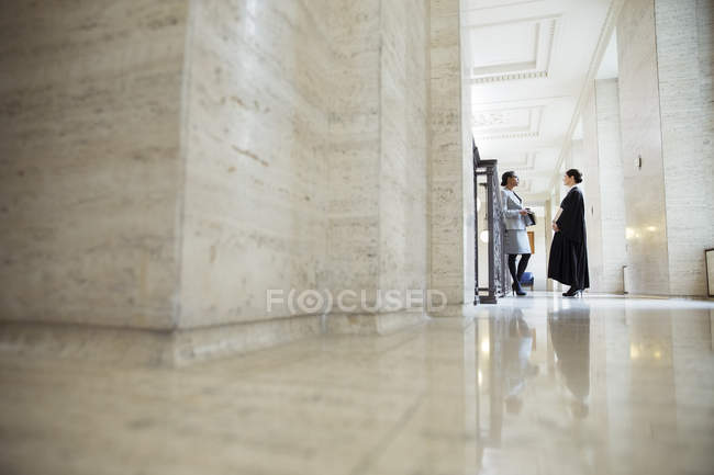 Lawyer and judge talking in hallway of courthouse — Stock Photo