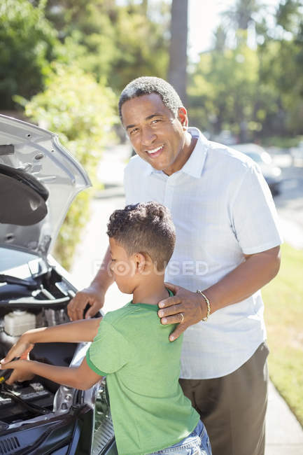 Ritratto del nonno sorridente che lavora al motore dell'automobile con il nipote — Foto stock