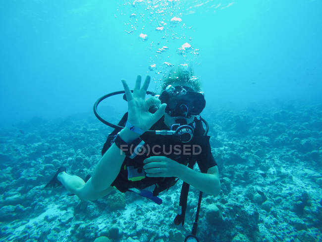 Porträt eines Tauchers, der unter Wasser gestikuliert — Stockfoto