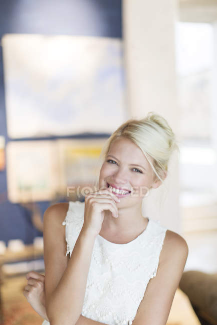 Donna sorridente in piedi in soggiorno — Foto stock