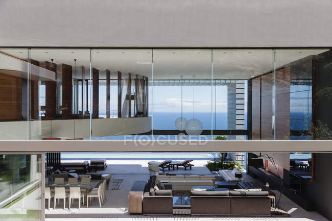 Glass walls of modern house overlooking ocean — Stock Photo