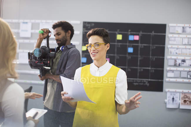 Female vlogger and cameraman preparing in office — Stock Photo