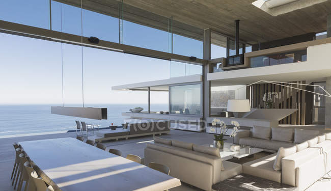 Современные, роскошные витрины интерьера гостиная и столовая с видом на океан — стоковое фото