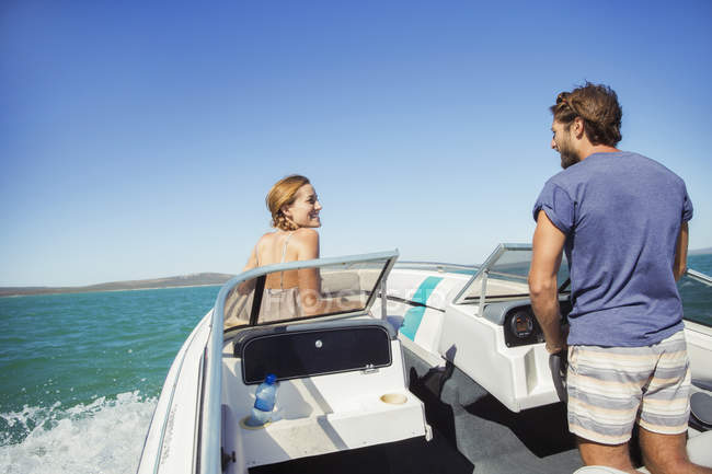 Mann steuert Boot mit Freundin — Stockfoto