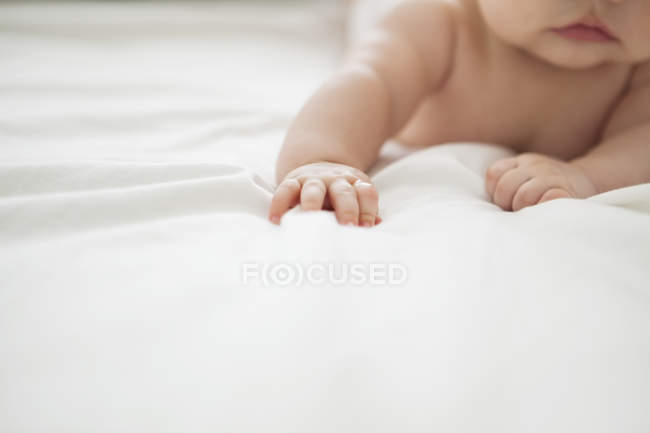 Entzückendes kleines Mädchen auf dem Bett liegend — Stockfoto