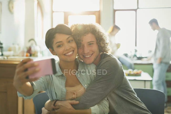 Sonriendo cariñosa joven pareja tomando selfie con cámara de teléfono - foto de stock