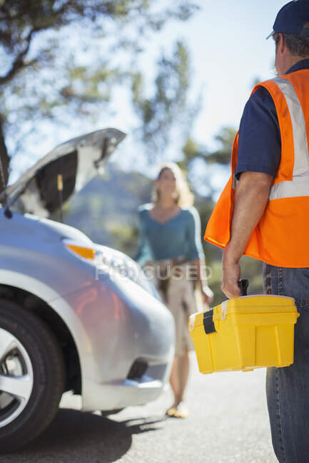 Mecânico de estrada chegando para ajudar a mulher — Fotografia de Stock