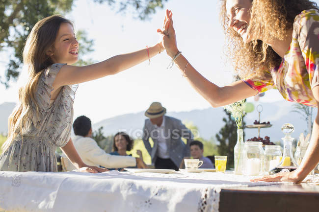 Mother and daughter high fiving outdoors — Stock Photo