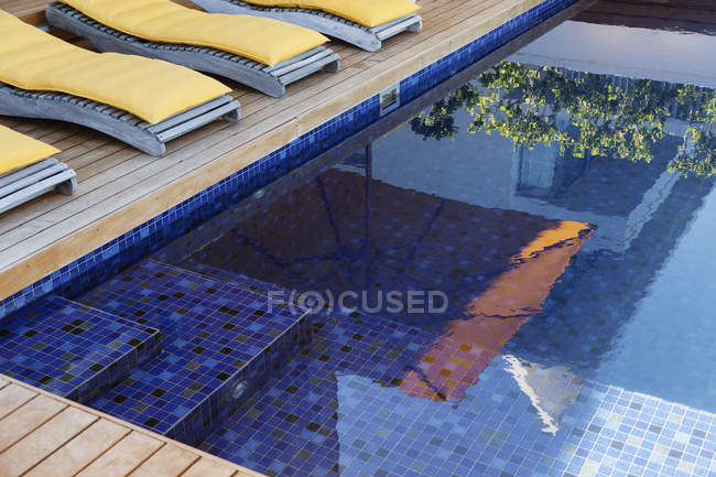 Reflejo de paraguas en piscina de lujo - foto de stock