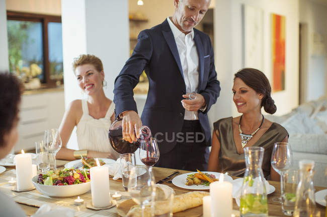 Mann schenkt Wein bei Dinnerparty ein — Stockfoto