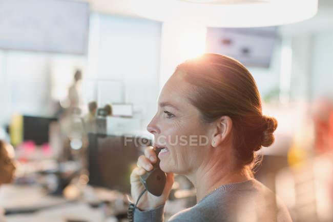 Профіль бізнес-леді розмовляє по телефону в офісі — стокове фото