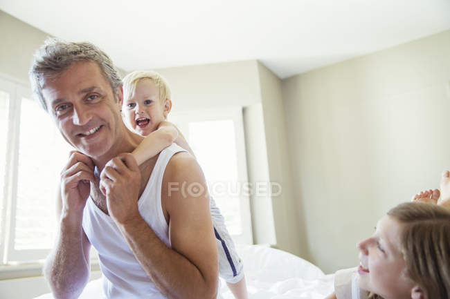 Father and children playing on bed — Stock Photo