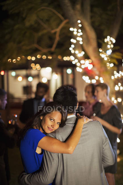 Couple hugging at party — Stock Photo