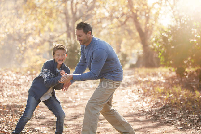 Padre e figlio giocherellone sul sentiero nel bosco — Foto stock