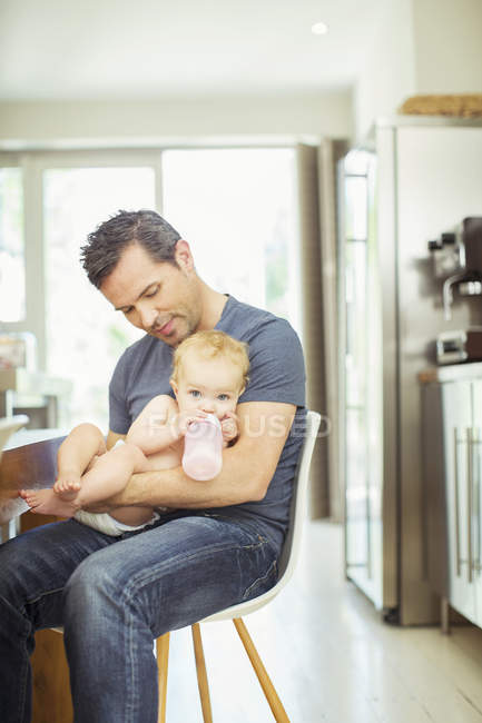 Pai alimentando bebê na cozinha — Fotografia de Stock