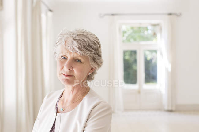 Donna anziana in salotto vuoto — Foto stock