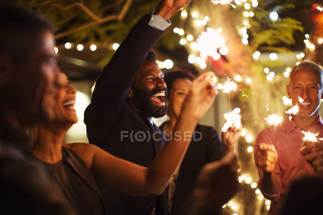 Friends playing with sparklers at party — Stock Photo