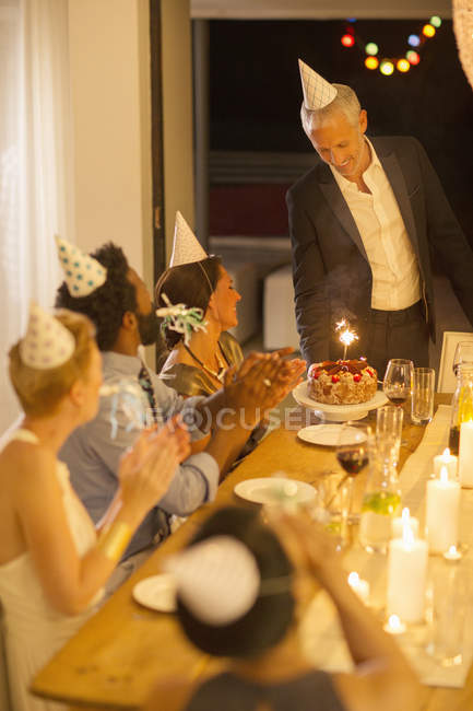 Чоловік подає торт на день народження на вечірці — стокове фото