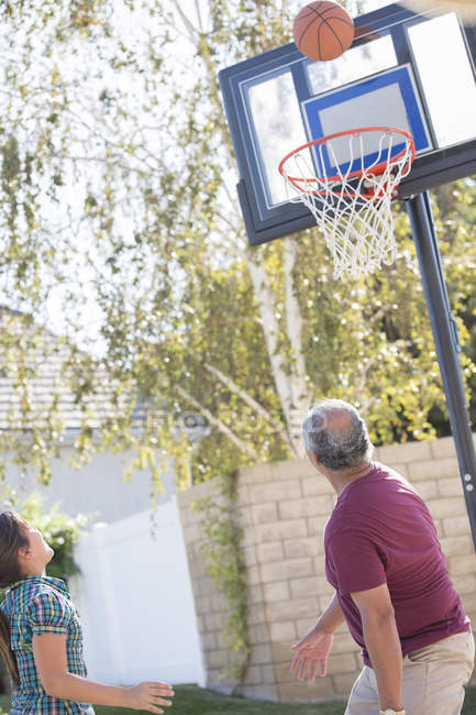Grand-père et petite-fille jouant au basket — Photo de stock