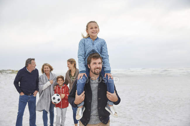 Familia multigeneracional caminando en la playa de invierno - foto de stock