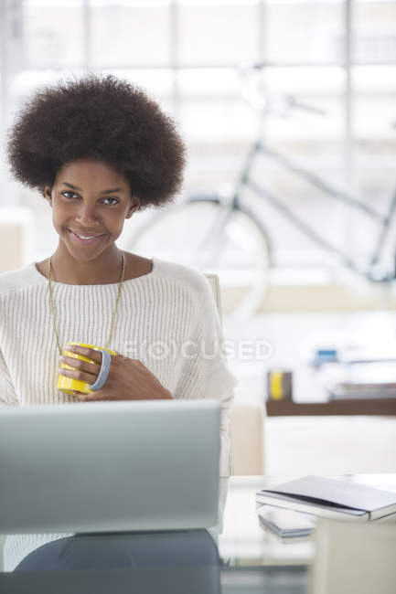 Woman using laptop at desk at home — Stock Photo