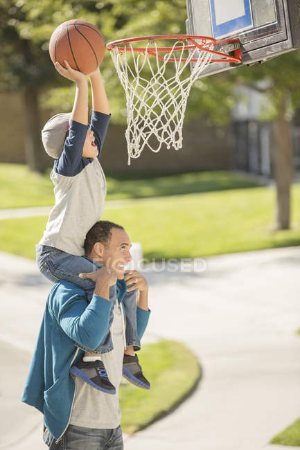 Padre e hijo jugando baloncesto en la entrada - foto de stock