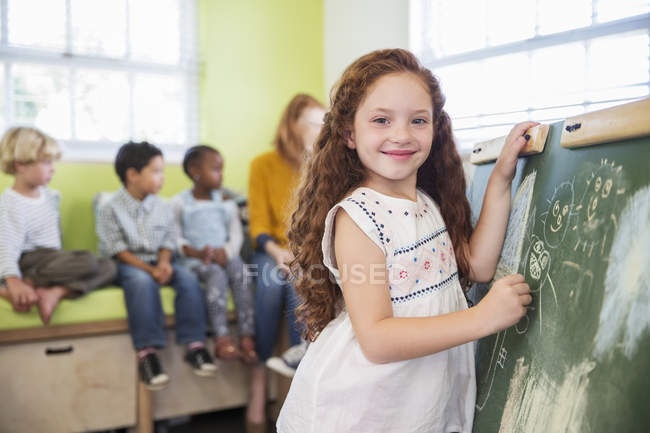 Student drawing on chalkboard in classroom — Stock Photo