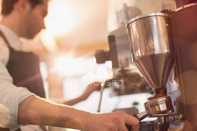 Barista using espresso machine grinder in cafe — Stock Photo