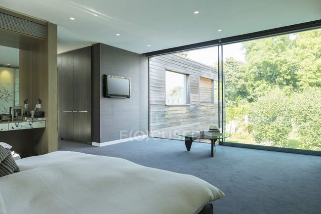 Стеклянная стена спальни в современном доме — стоковое фото