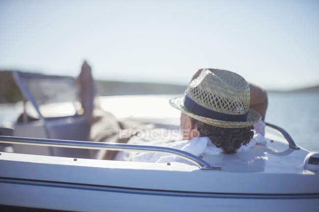Hombre mayor relajándose en barco en el agua - foto de stock