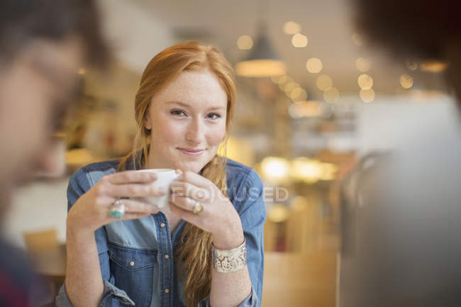 Happy young friends enjoying coffee in cafe — Stock Photo