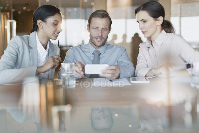 Business people using cell phone in conference room meeting — Stock Photo
