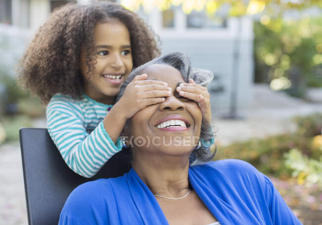 Granddaughter surprising grandmother on patio — Stock Photo