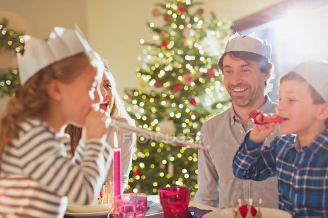 Familie trägt Papierkronen am Weihnachtstisch — Stockfoto