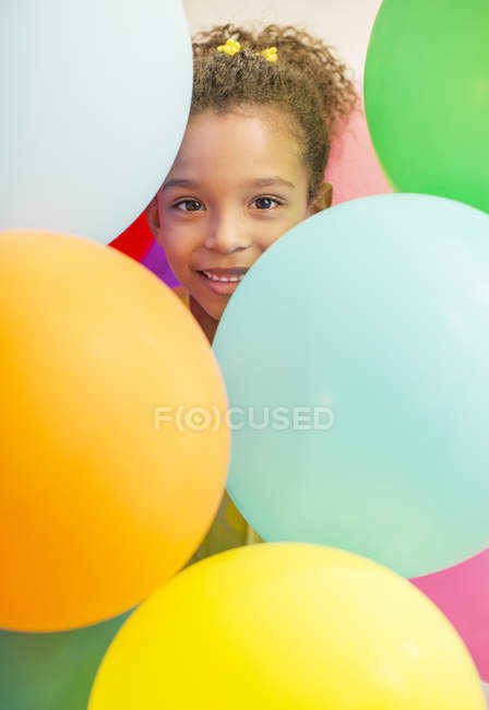 Chica joven rodeada de globos - foto de stock