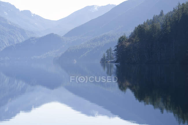 Berge spiegeln sich tagsüber in ruhigem See wider — Stockfoto