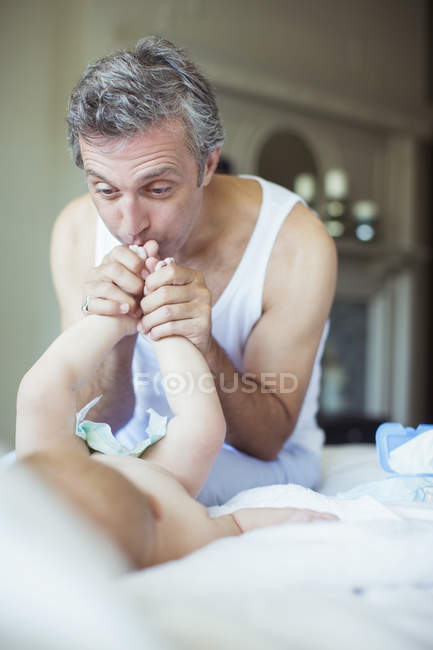 Père embrassant les pieds du bébé — Photo de stock