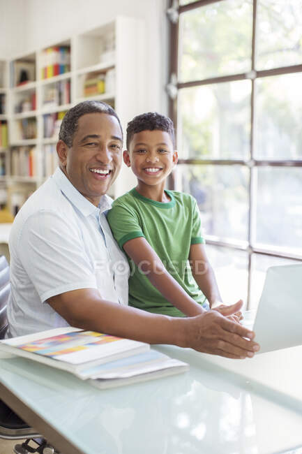Портрет улыбаясь дед и внук, используя ноутбук — стоковое фото