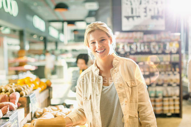 Ritratto sorridente giovane donna spesa nel mercato — Foto stock