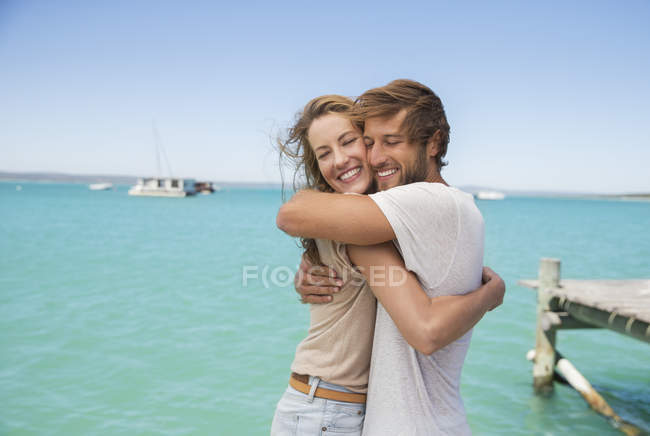 Casal abraçando perto de água — Fotografia de Stock