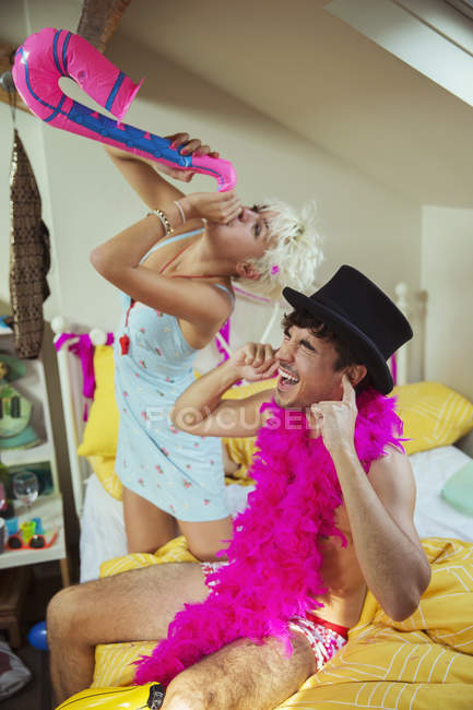 Blonde girl playing inflatable sax in bedroom — Stock Photo