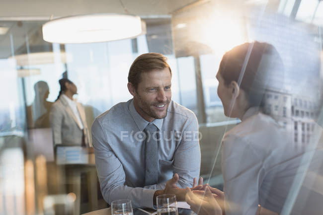 Бизнесмен и деловая женщина разговаривают в офисе — стоковое фото