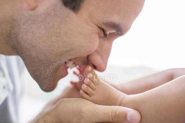 Pai beijando os pés do menino — Fotografia de Stock