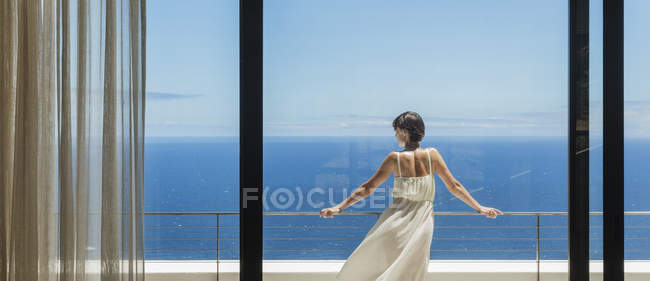 Frau blickt vom Balkon auf Meer — Stockfoto