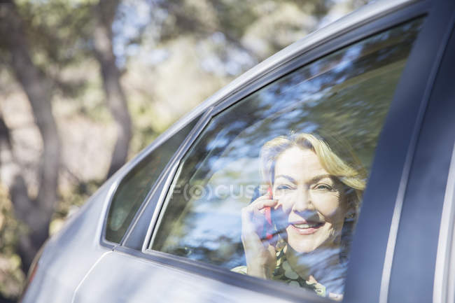 Seniorin telefoniert im Auto mit Handy — Stockfoto